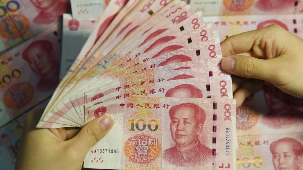 A man holds 100 yuan notes.