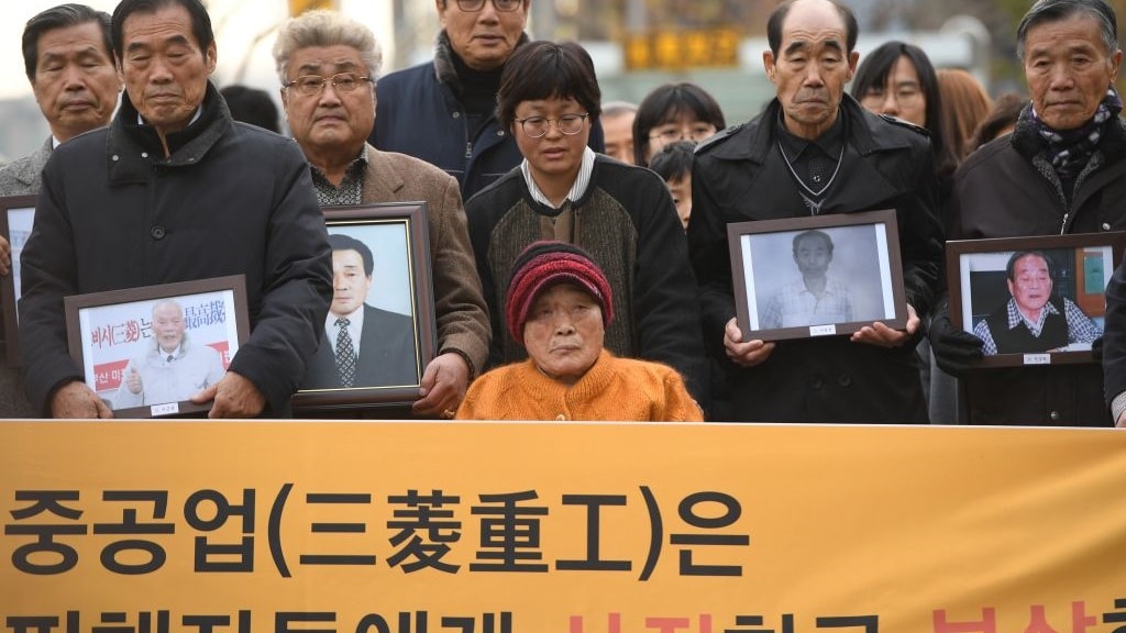 Kim Sung-joo (C bottom), a victim of forced labour by Japan during its colonial rule of the Korean peninsula from 1910 to 1945, and relatives of other victims arrive at the Supreme Court in Seoul on November 29, 2018.