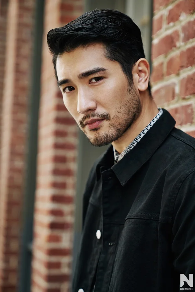 Portrait of Godfrey Gao beside a brick wall
