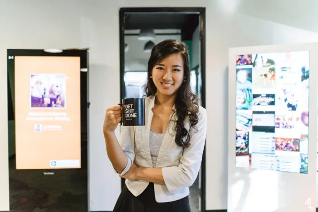 Nanxi Liu holding a mug beside Enplug displays