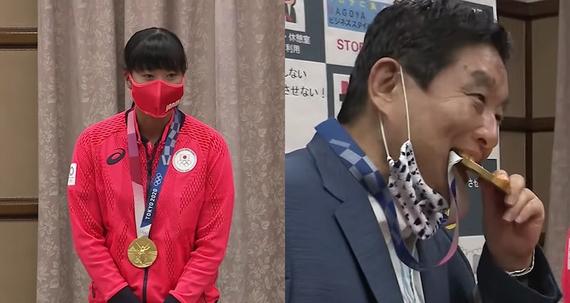 Nagoya mayor Takashi Kawamura biting gold medal